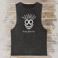 A dark washed sleeveless tank top laid flat on a rustic wood plank background. The shirt features a white graphic of a smiling face with wavy hair and the text 'Resting Beach Face' printed below.