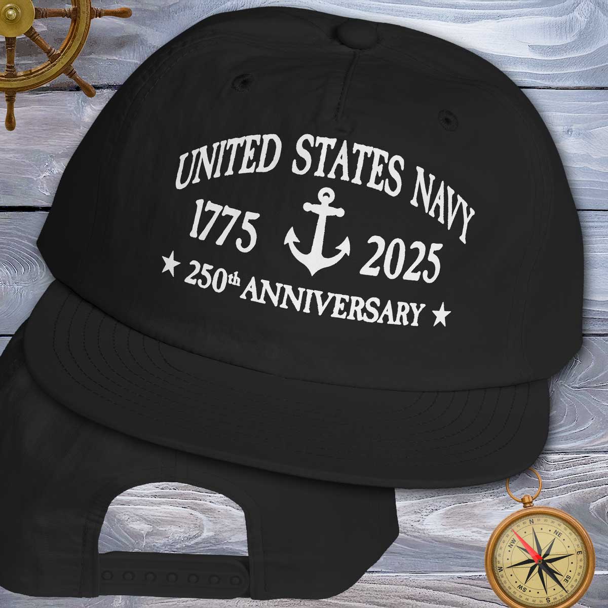 Black cap with 'United States Navy 1775-2025 250th Anniversary' text on a wooden background.