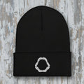 Black beanie with a white shark jaw embroidery on a rustic wood background
