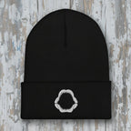 Black beanie with a white shark jaw embroidery on a rustic wood background