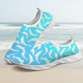A pair of slip-on water shoes featuring a bright turquoise blue upper covered in a white dolphin pattern, with white soles, shown on a clean white background.