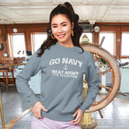 Woman wearing a blue Jean sweatshirt with 'Go Navy, Beat Army, It's Tradition' text in a ship's wheelhouse.