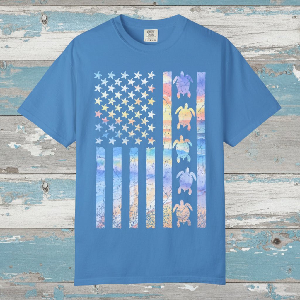 Blue t-shirt with a colorful American flag design featuring turtles on a nautical wood background