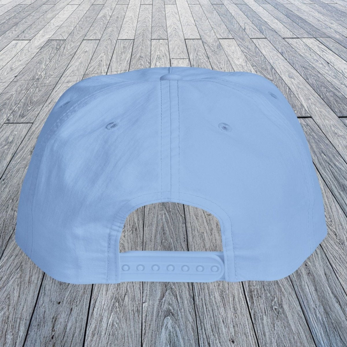 A light blue baseball cap shown from the back, placed on a gray wooden plank surface.
