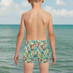 boy wearing swim trunks with a tropical ParrotHead pattern looking out over the sea in Key West