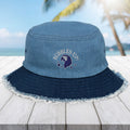Blue bucket hat with 'Bubbles Up' logo on a wooden surface with a beach background