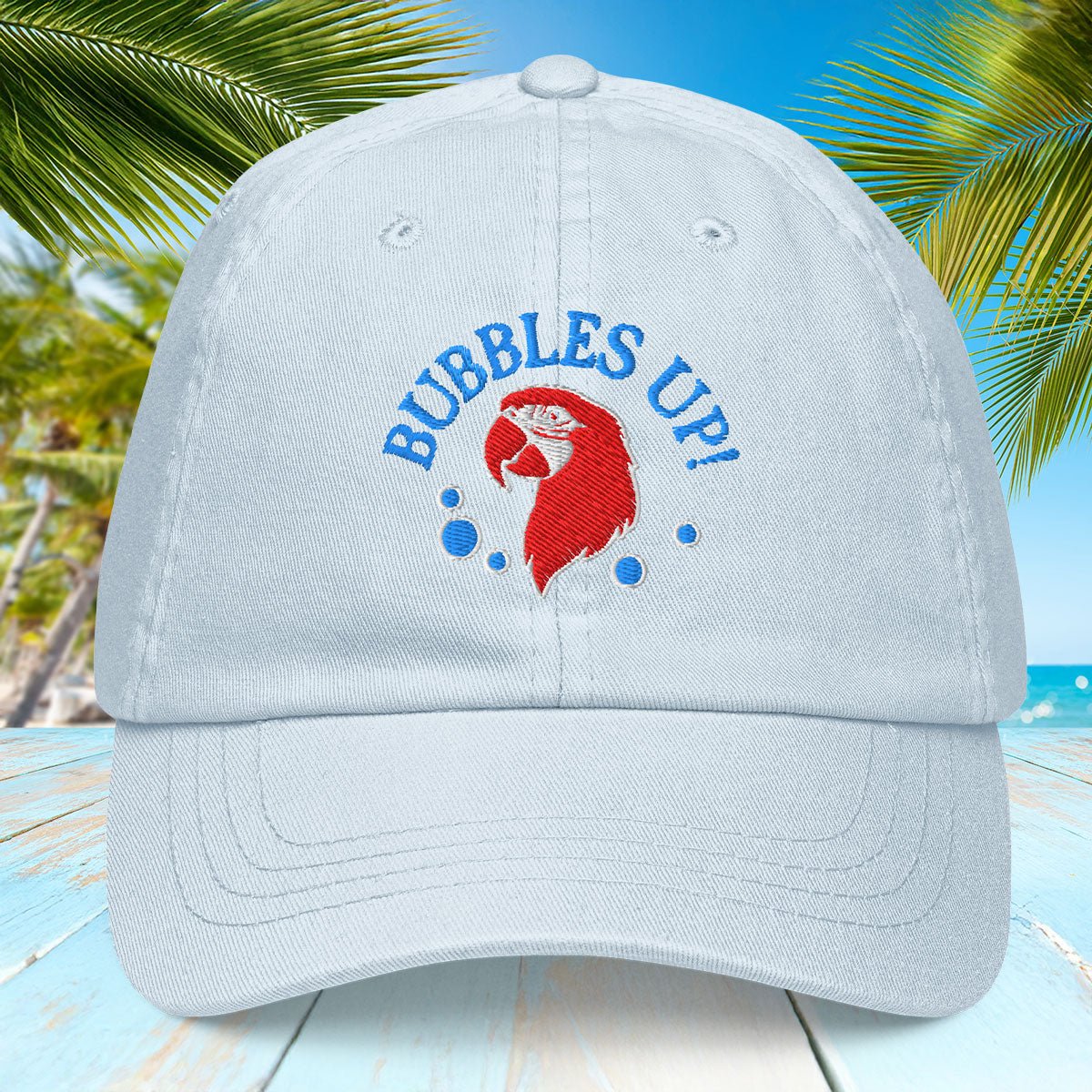 Pastel Blue cap with 'Bubbles Up!' design on a beach background