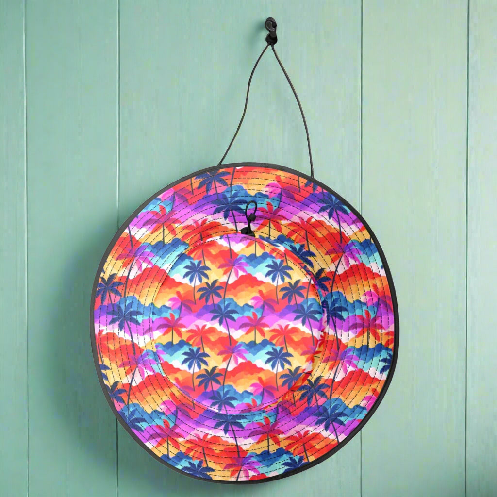 Colorful Sun Hat with black strap hanging on a hook in the wall of a beachside cafe'