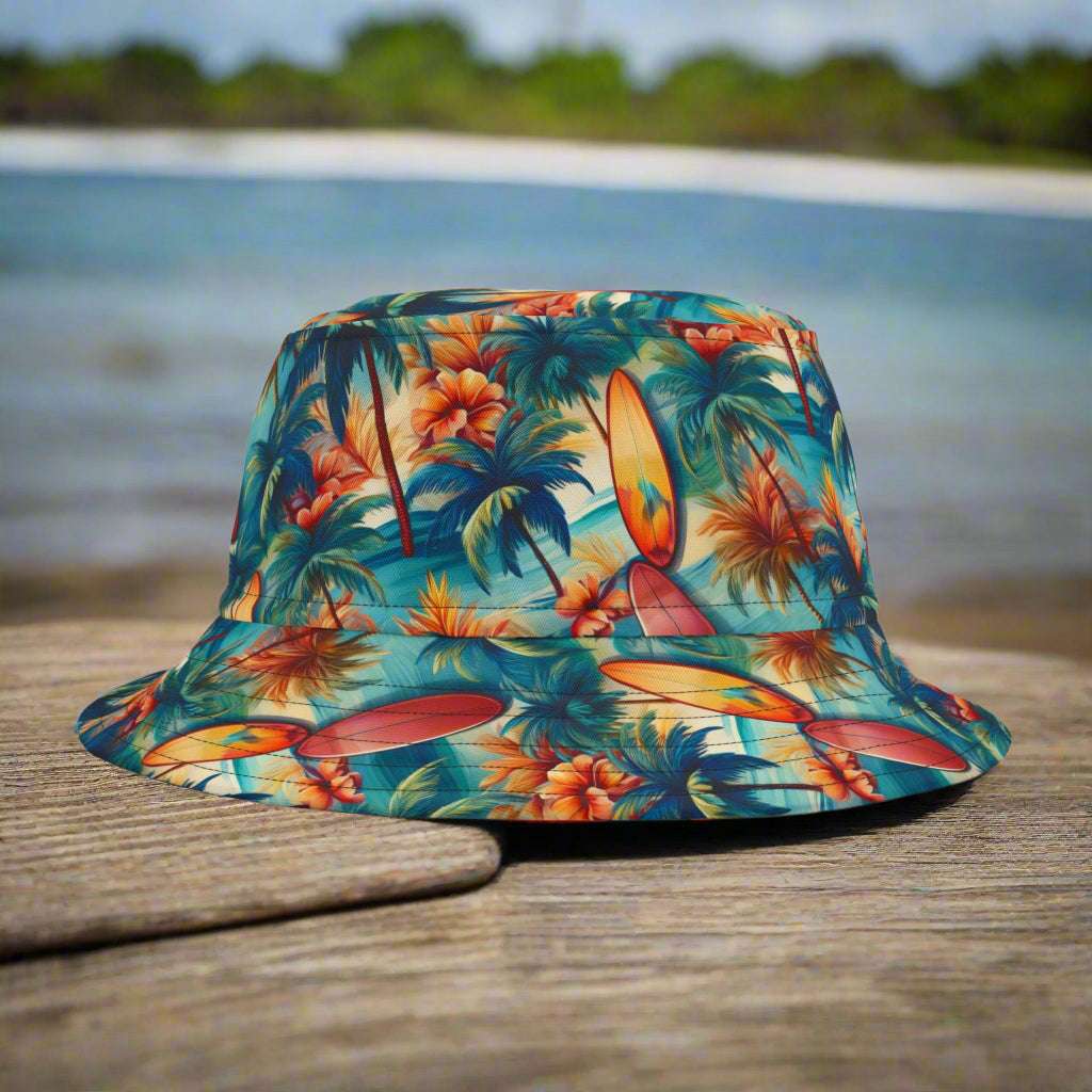 Bucket hat with Hawaiian style surfboard pattern sitting on a rustic wood table next to a surf shack in Waikiki