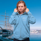 Person wearing a blue ParrotHead Hoodie with a ship and waterfront in the background