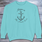 Light blue sweatshirt with anchor design and text on a wooden surface