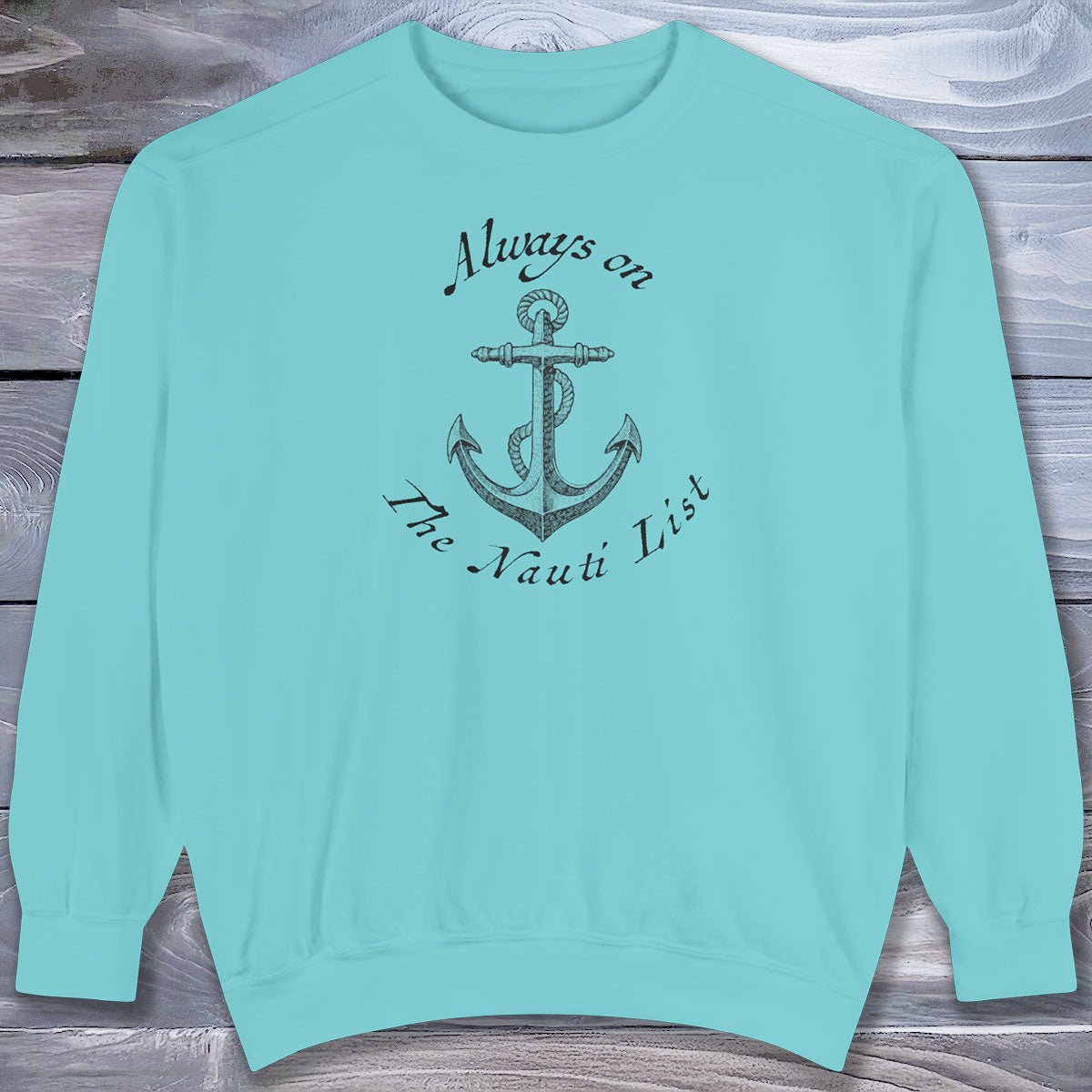 Light blue sweatshirt with anchor design and text on a wooden surface