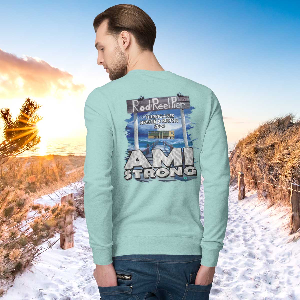 Person wearing a light blue sweatshirt with 'AMI STRONG' text and graphic, standing in a snowy landscape.