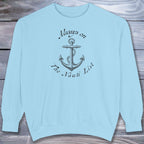 Light blue sweatshirt with anchor design and text on a wooden surface