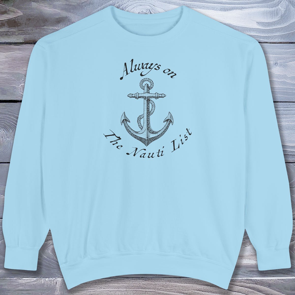 Light blue sweatshirt with anchor design and text on a wooden surface