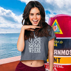 Woman wearing a charcoal gray t-shirt with text "It's 5 O'clock Somewhere" at the Southernmost marker in Key West .