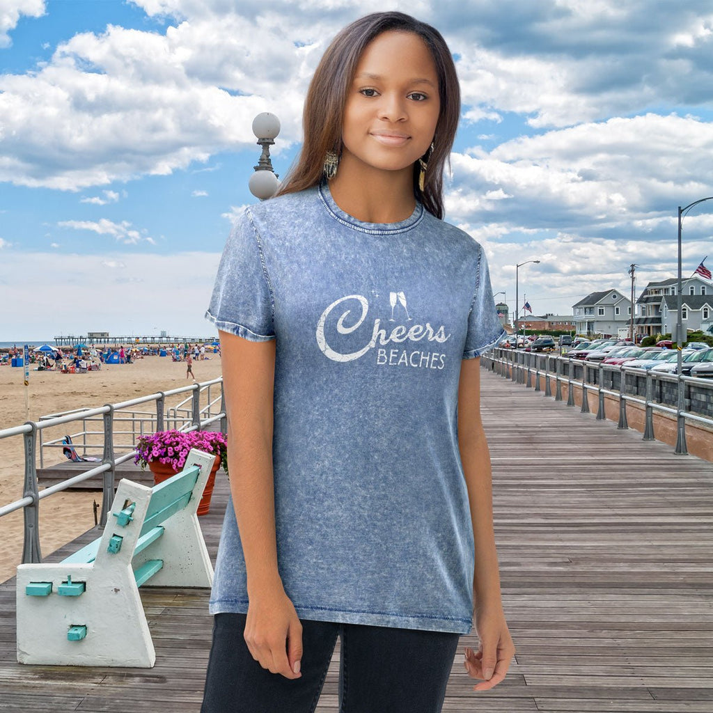Person wearing a blue 'Cheers Beaches' t-shirt on a beach boardwalk.