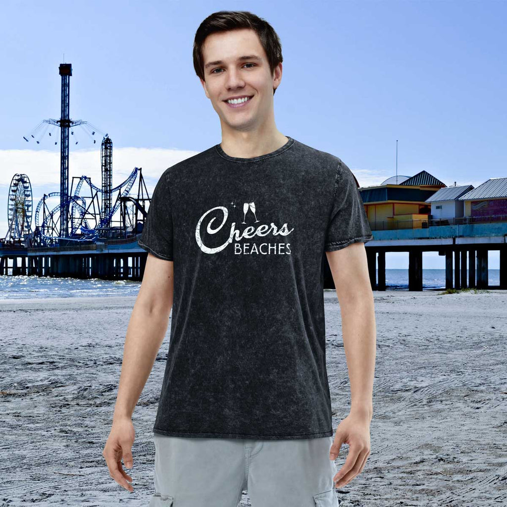 Person wearing a 'Cheers Beaches' t-shirt on a beach with a pier and Ferris wheel in the background.