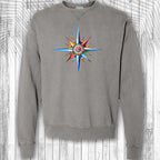 Gray sweatshirt with a colorful compass design on a wooden background