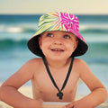 Child wearing a colorful sun hat with a beach background