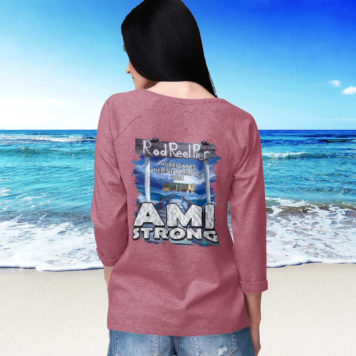 Person wearing a pink long-sleeve shirt with 'AMI STRONG' text on the beach