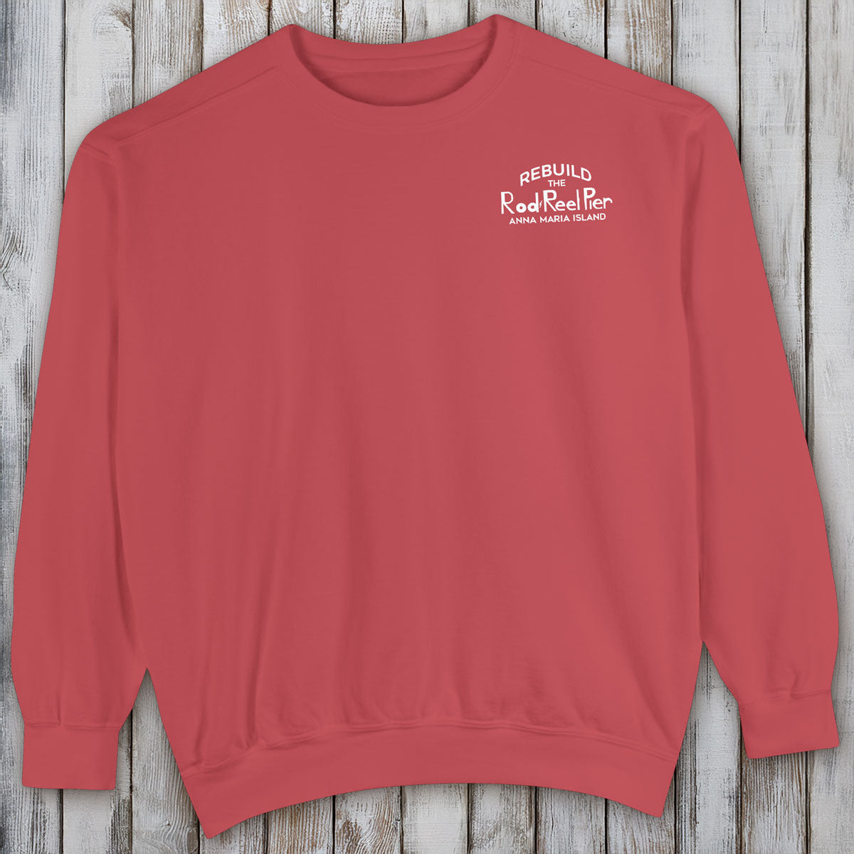 Red sweatshirt with text on a wooden surface