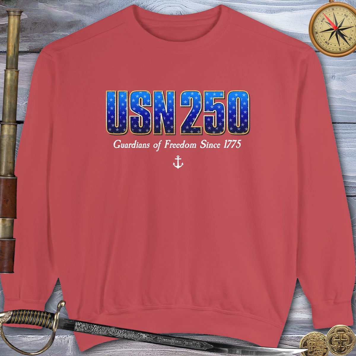 Red sweatshirt with 'USN 250 Guardians of Freedom Since 1775' text on a wooden background