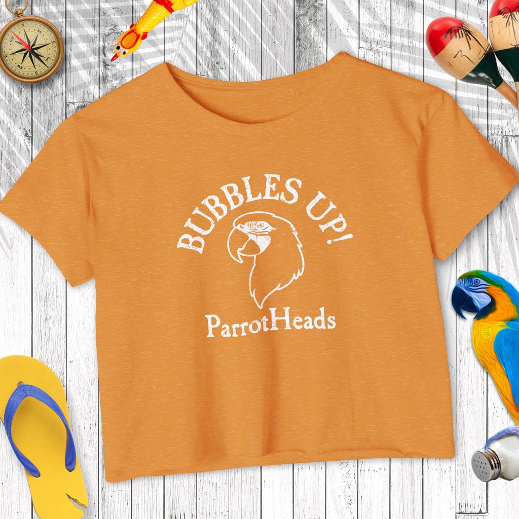 Orange t-shirt with 'Bubbles Up! ParrotHeads' text and parrot graphic on a wooden surface.