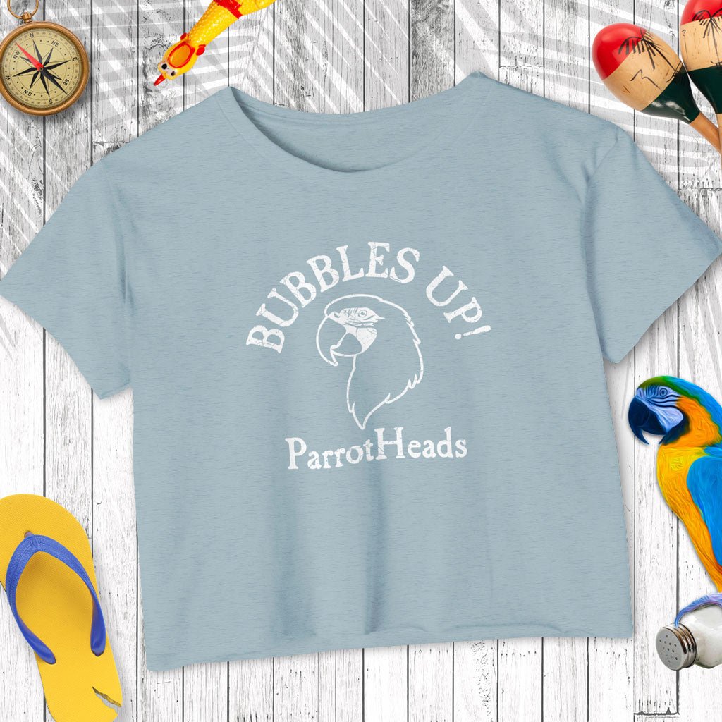 Light blue t-shirt with 'Bubbles Up! ParrotHeads' text and parrot graphic on a wooden surface.