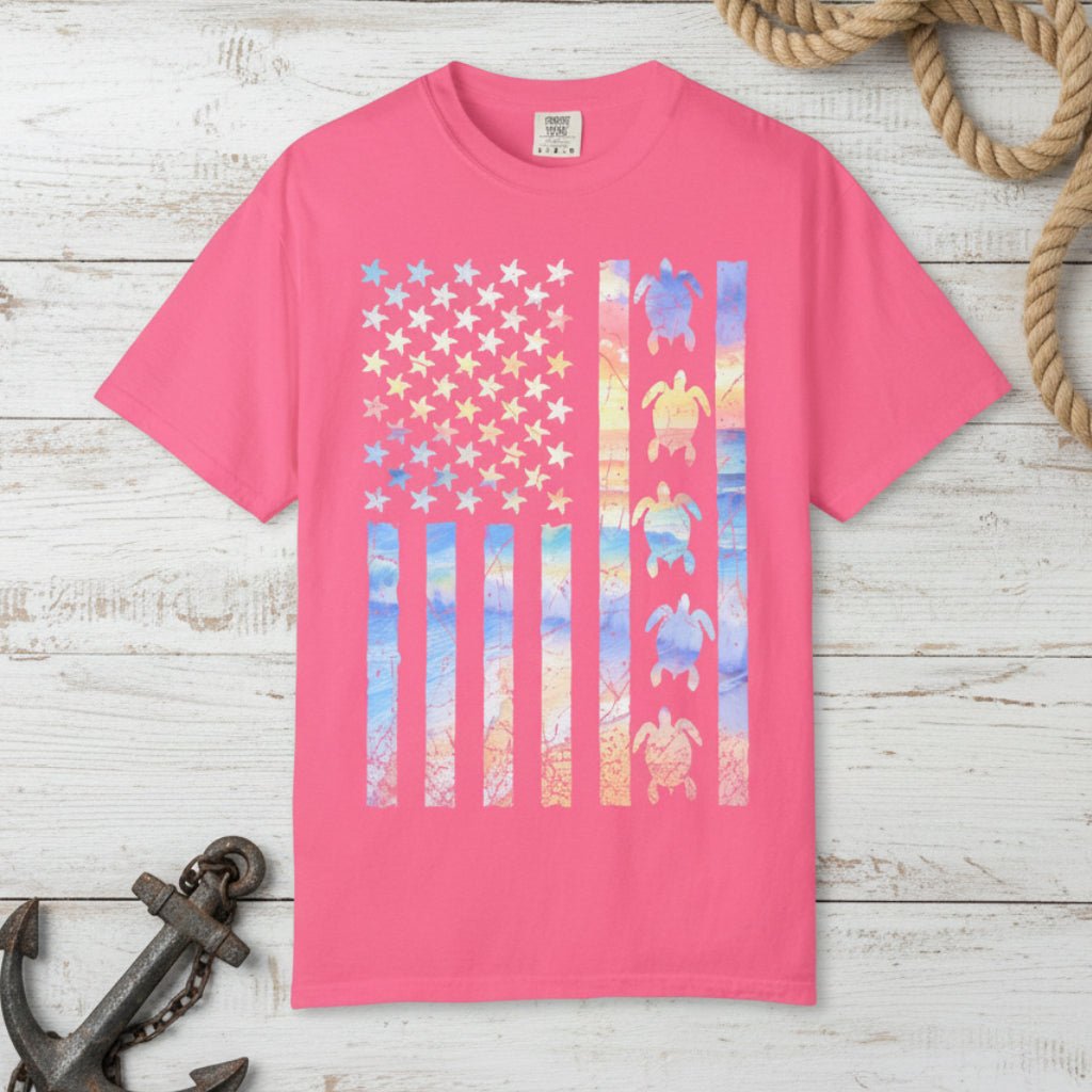 Pink t-shirt with a colorful American flag design featuring turtles on a nautical background