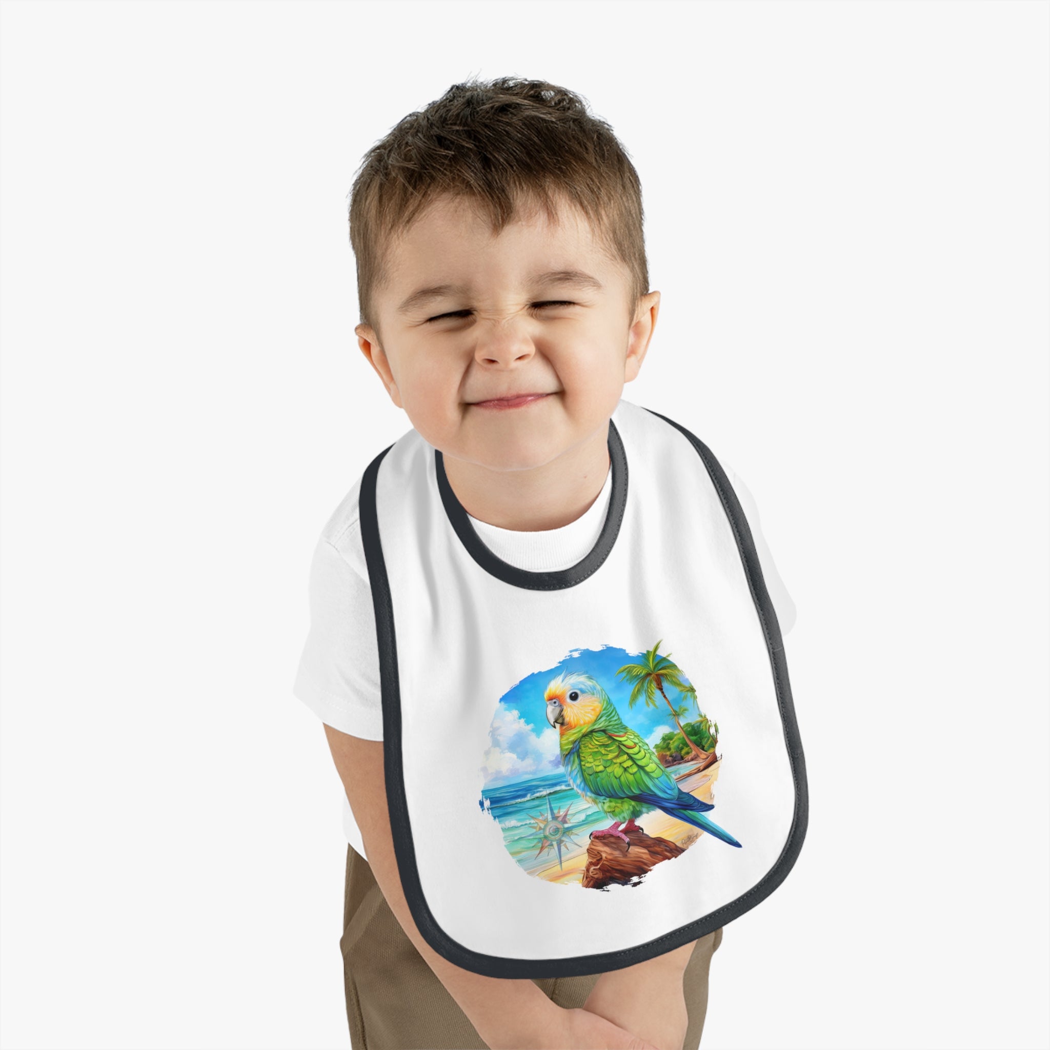 A baby wearing a white bib with a colorful parakeet and tropical design.