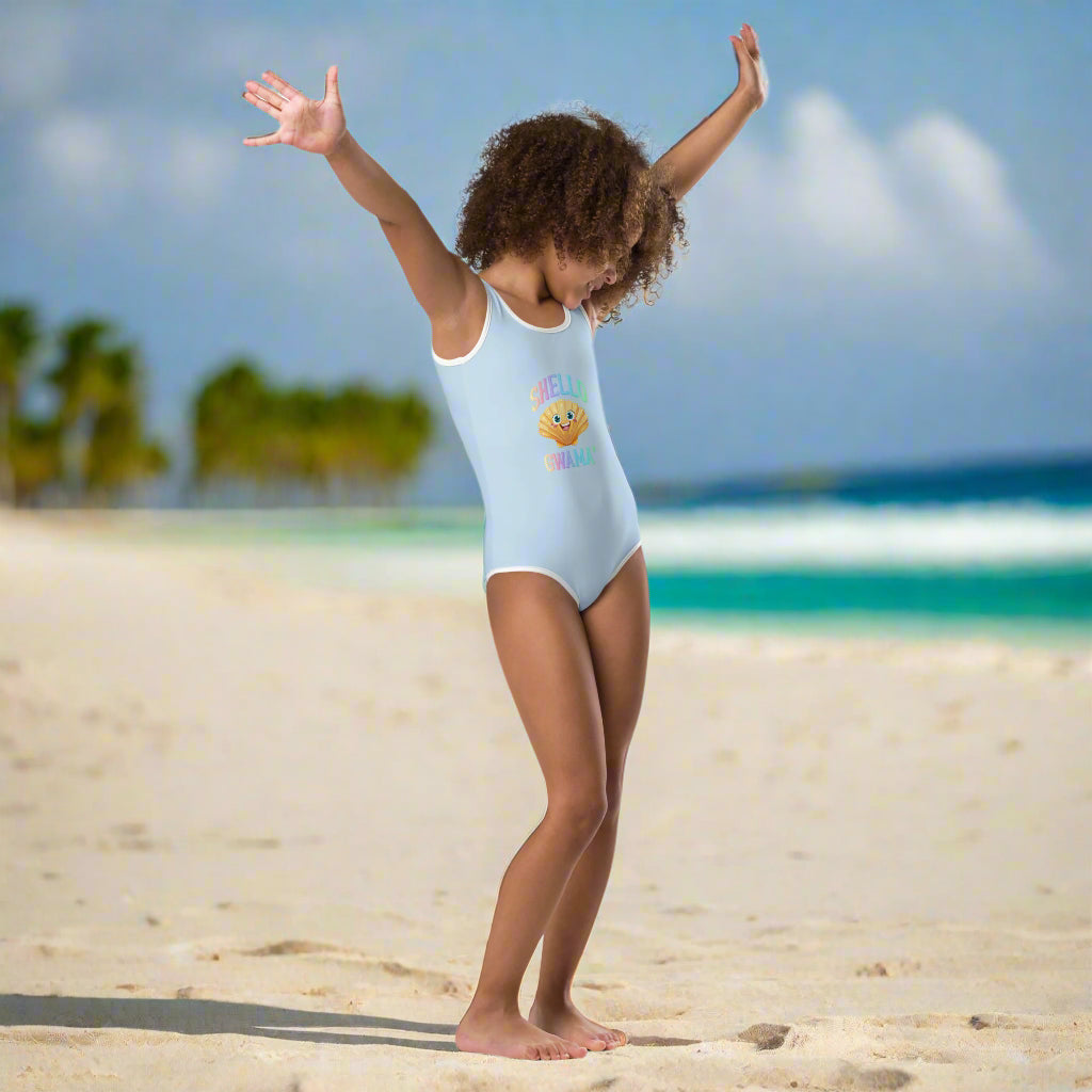 Kid wearing Sky Blue Girl's One Piece Swimsuit saying SHello Gwama' dancing in the sand in an island paradise