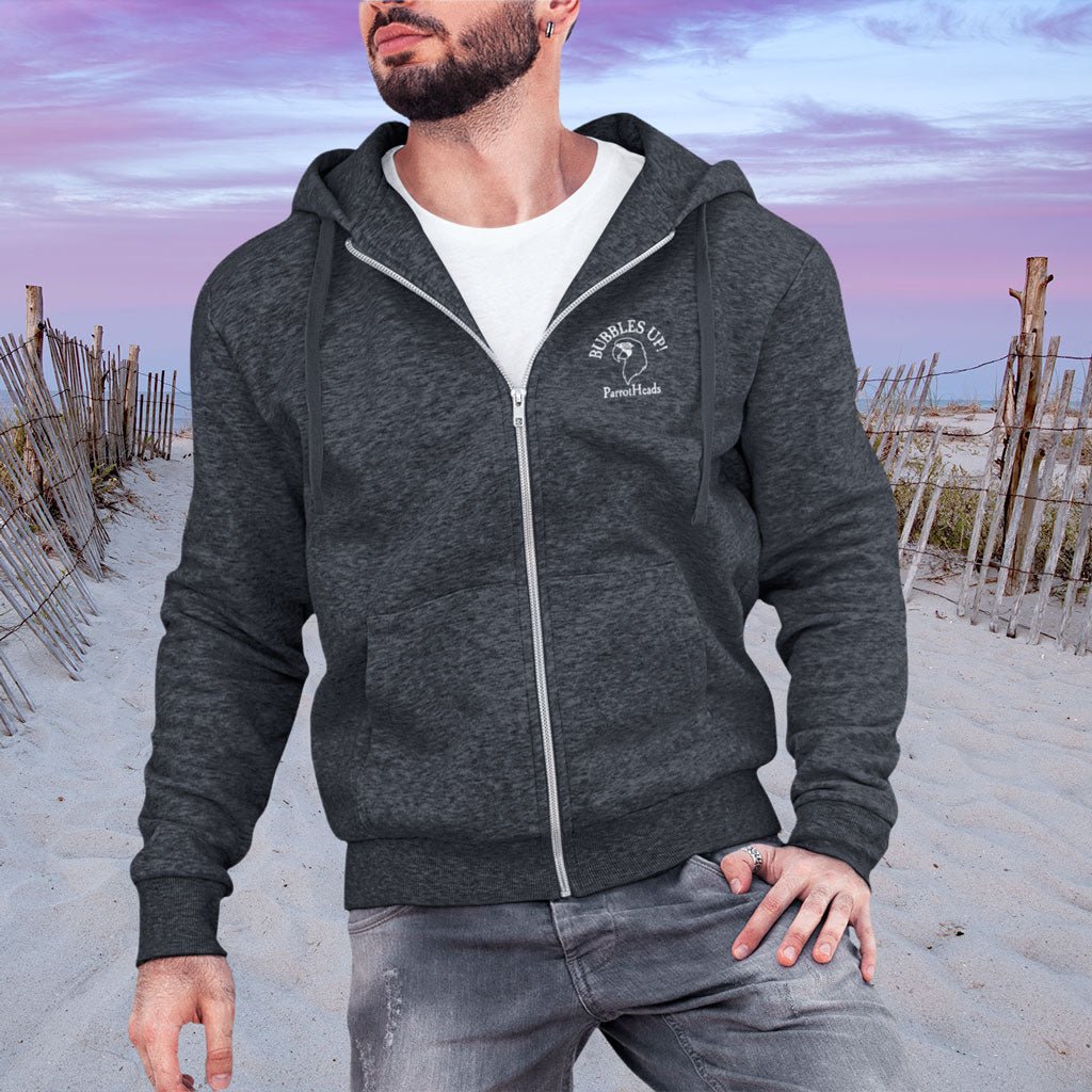 Man wearing a gray ParrotHead Hoodie with a logo on a beach background