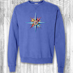 Blue sweatshirt with a colorful compass design on a wooden background