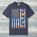Navy blue t-shirt with a colorful American flag design featuring turtles on a nautical wood background