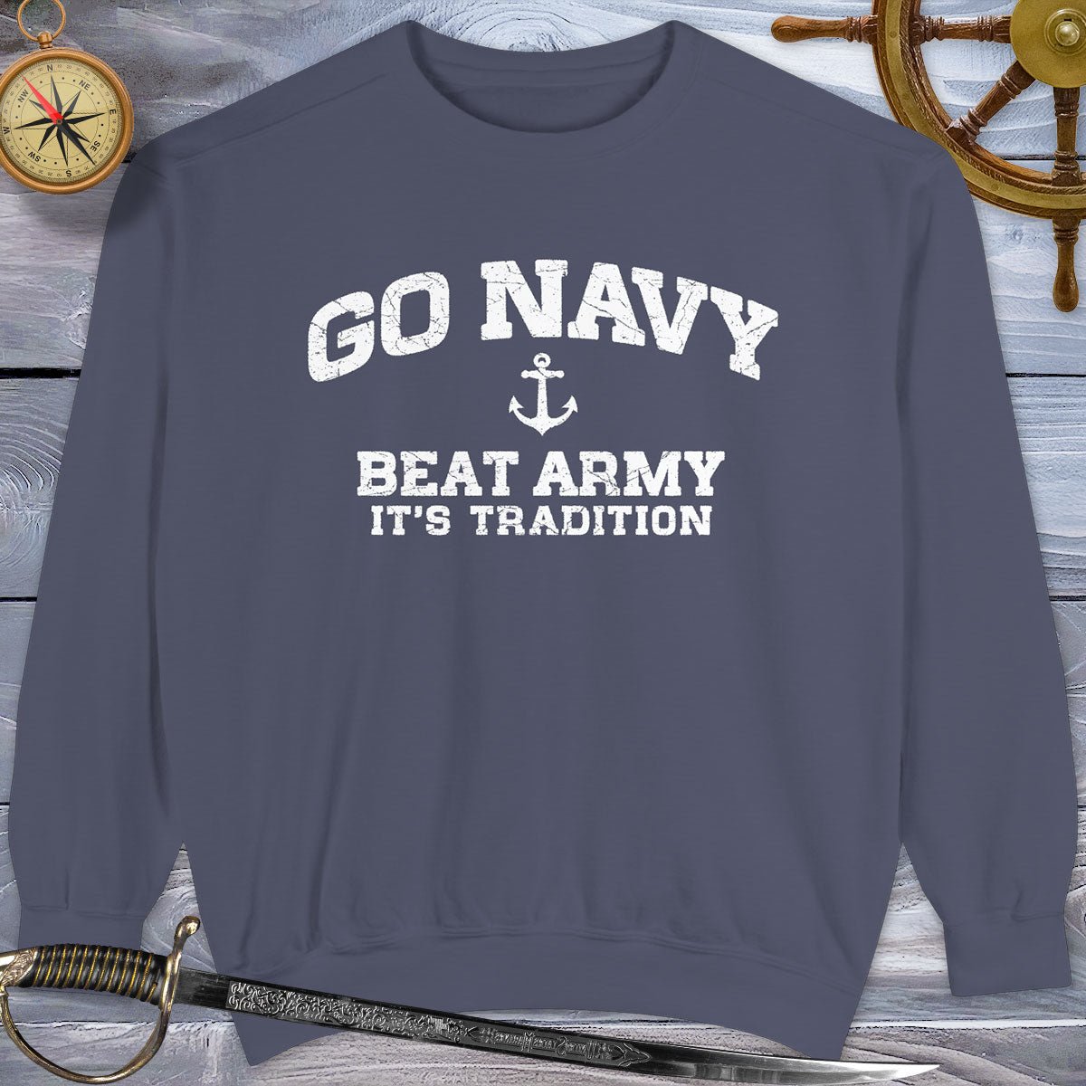 Navy blue sweatshirt with 'Go Navy, Beat Army, It's Tradition' text on a wooden background.