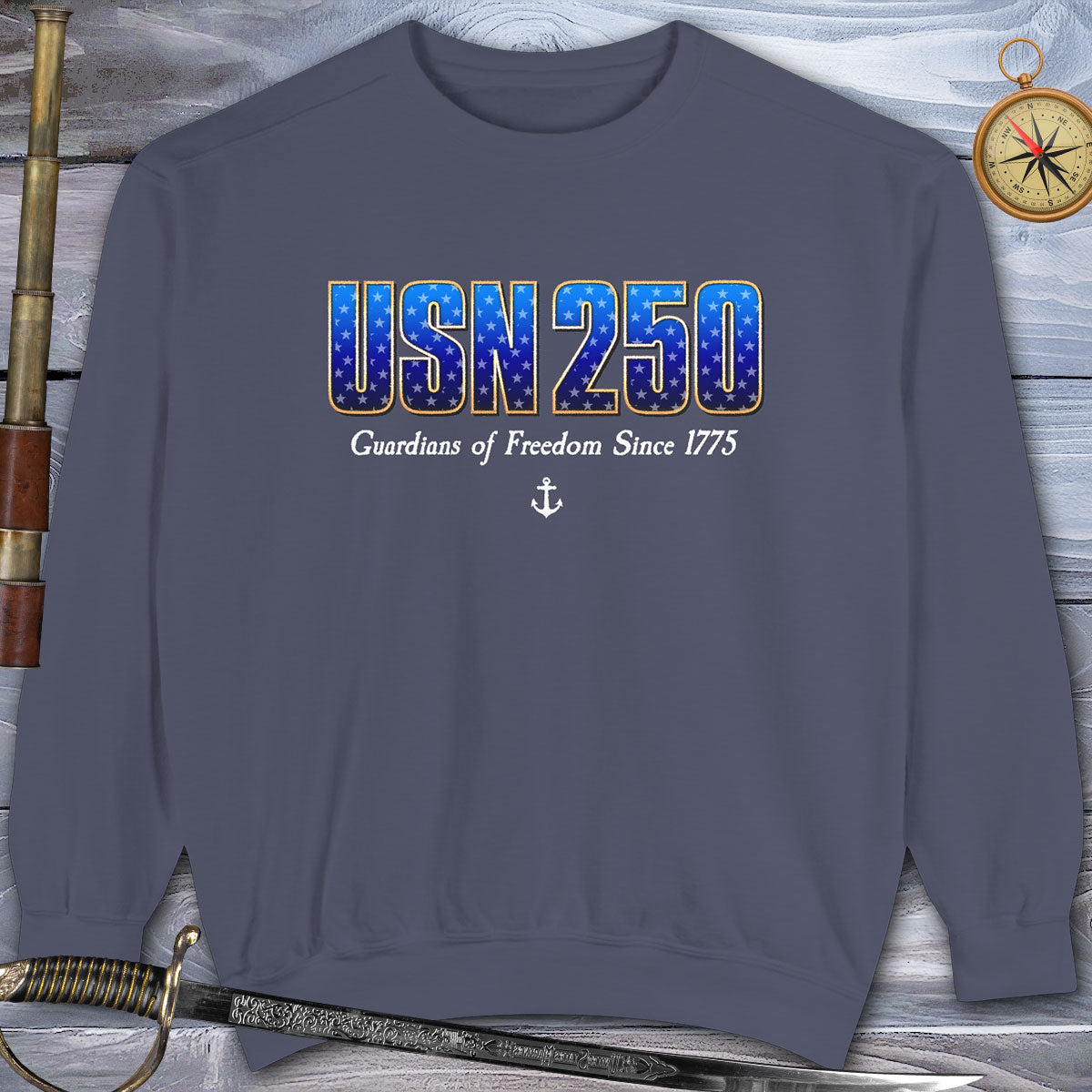 Navy blue sweatshirt with 'USN 250 Guardians of Freedom Since 1775' text on a wooden background.