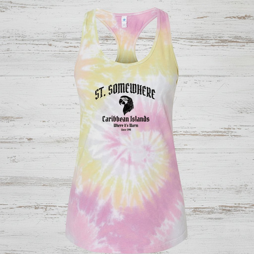 A women's racerback tank top with a pink, yellow, and white spiral tie-dye pattern. The front features a graphic print with the text 'ST. Somewhere, Caribbean Islands, Where it's warm. Since 1946