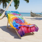 Beach Towel with Dolphins circling each other over tie dye print laid out across a beach lounger. 