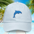 Pastel blue cap with blue dolphin design against a tropical background