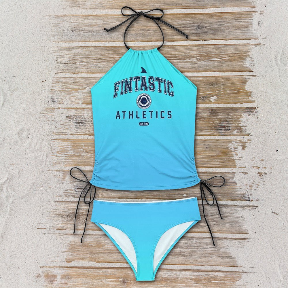 Blue bikini set with 'Fintastic Athletics' text on a wooden surface