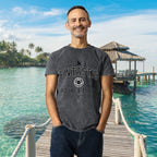 Man wearing a 'FNTASTIC ATHLETICS' t-shirt standing on a wooden dock with a tropical background.