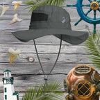 Gray sun hat with chin strap on a wooden background with nautical decorations.