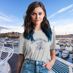Woman wearing a t-shirt with a graphic design in front of a marina.