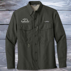 Dark green Fishing Shirt with branding on a wooden background