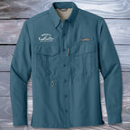 Teal Fishing Shirt with branding on a wooden background