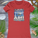 Red t-shirt with 'AMI Strong' graphic on a wooden surface with decorative elements.