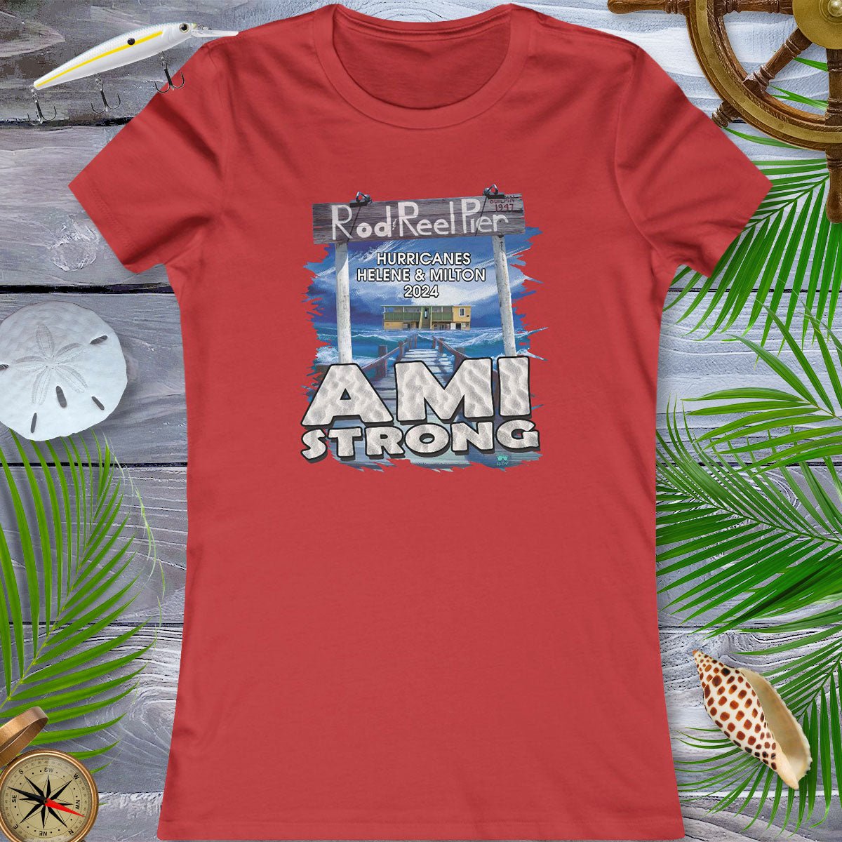 Red t-shirt with 'AMI Strong' graphic on a wooden surface with decorative elements.