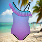 Gradient violet to blue swimsuit with ruffled top hanging on a line in a beach island paradise