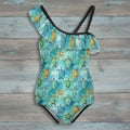 One-piece swimsuit with turtle pattern on a rustic wood background